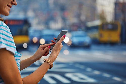 Student on Cell Phone Waiting to Catch Bus